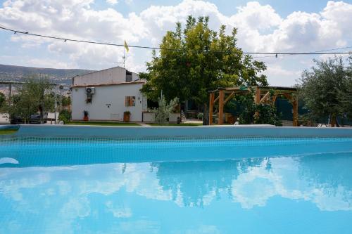 a large blue swimming pool in front of a house at Filuvespri in Comiso
