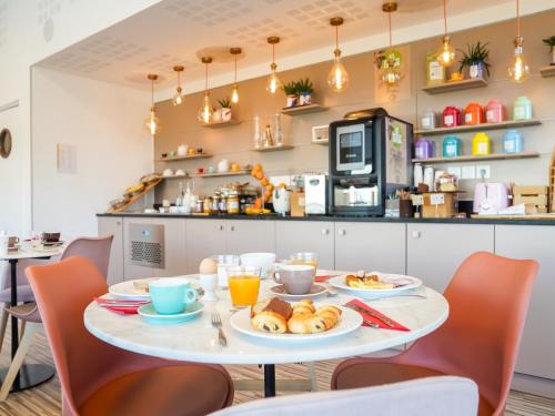 una mesa con platos de comida en la cocina en Séjours & Affaires Paris-Vitry, en Vitry-sur-Seine
