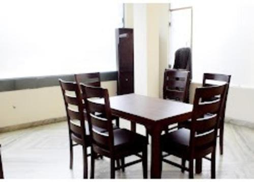 Una mesa y sillas de madera en una habitación. en Blessing Inn Hotel, en Jalandhar