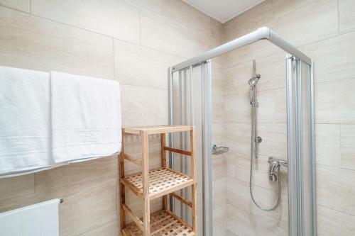 a bathroom with a shower and a wooden shelf at Terrazza Paradiso by Quokka 360 - Spacious Design Flat with Terrace in Paradiso