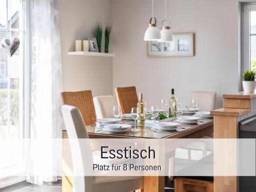 ein Esszimmer mit einem Tisch mit Stühlen und einem Esszimmer in der Unterkunft Komfortables Ferienhaus Strandzauber auf Fehmarn für 8 Personen mit 4 Schlafzimmern und 2 Bädern in Fehmarn