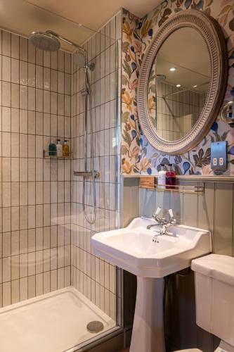 ein Badezimmer mit Waschbecken und Dusche in der Unterkunft The Bay Tree Hotel in Burford