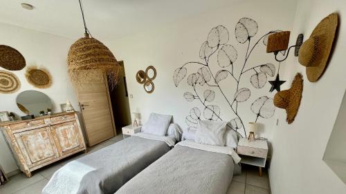 Chevigny-en-ValièreにあるGîte de la Valièreのベッドルーム1室(ベッド2台付)、花の壁画のある壁