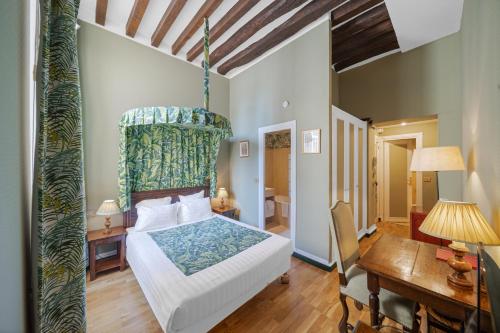 a bedroom with a large bed with a canopy at Hotel de la Bretonnerie in Paris