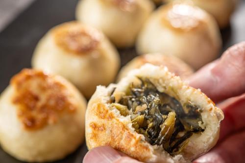 a person holding a piece of food in their hand at KAMENOI HOTEL Kusatsu Resort in Kusatsu