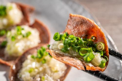 a piece of toast with green onions on it at KAMENOI HOTEL Kusatsu Resort in Kusatsu