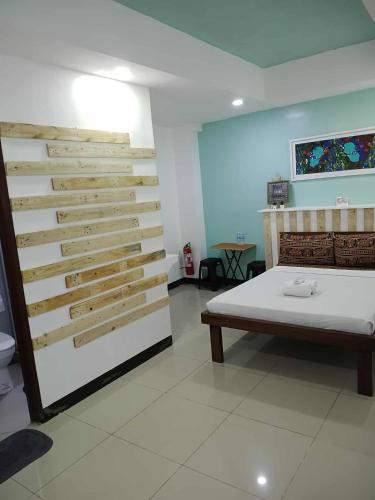Zimmer mit einem Bett und einer Holzwand in der Unterkunft D'Builders Rooms Hotel in Sampong