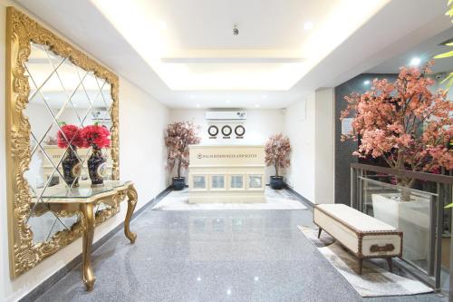 a room with a mirror and a table and flowers at Palm Residences and Suites in Jaipur