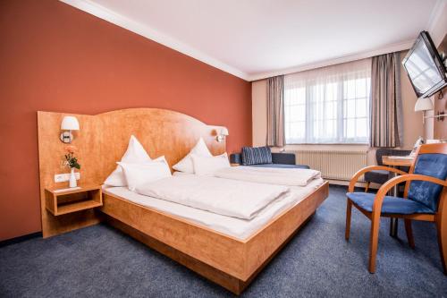 ein Hotelzimmer mit einem Bett und einem Schreibtisch in der Unterkunft Hotel zur Rose in Eglofs