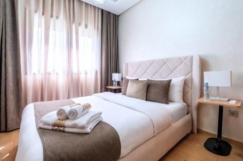 Un dormitorio con una cama grande con toallas. en Appartement Familial à Zenata avec Piscine, en Aïn Harrouda