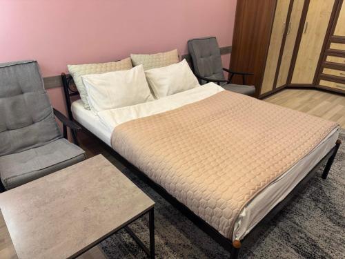 1 cama y 2 sillas en una habitación en Апартаменти, вул Космонавтів,29, великий Смарт TV , преміум підписки YouTube та онлайн-кінотеатрів, ЗВІТНІ ДОКУМЕНТИ, en Krivoy Rog