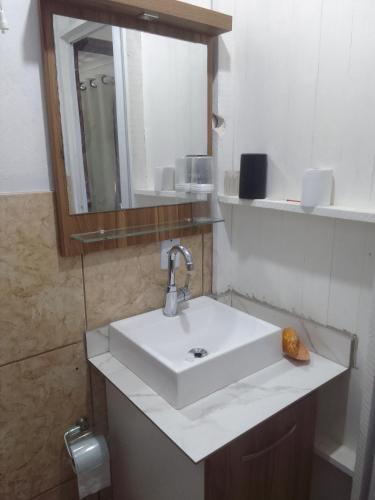 a bathroom with a white sink and a mirror at Estúdio em Capão da Canoa in Capão da Canoa