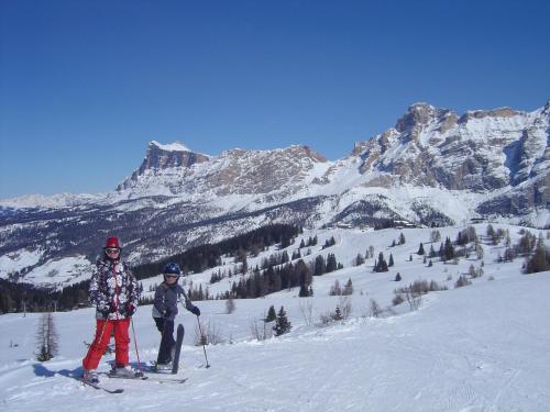 two people on skis in the snow on a mountain at Garni Irsara in San Cassiano