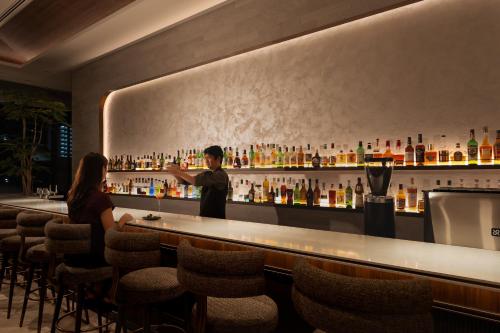 a man standing at a bar with a woman at Okinawa Harborview Hotel in Naha