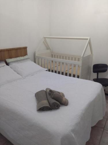a pair of shoes sitting on a white bed at Estúdio em Capão da Canoa in Capão da Canoa