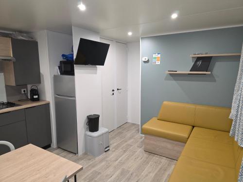 a living room with a couch and a kitchen at Houlgate - 279 - Magnifique Mobilhome 6 personnes sur Camping 5 étoiles in Houlgate