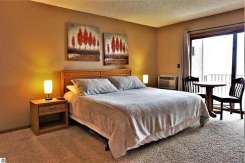 une chambre avec un lit, une table et des chaises dans l'établissement Shanty Creek Resort Bellaire Michigan, à Bellaire