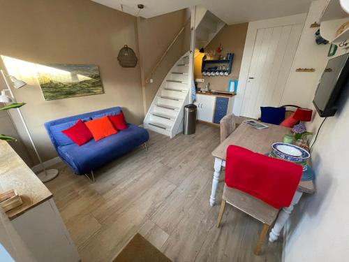 a living room with a blue couch and red pillows at Het Heertje in Den Hoorn