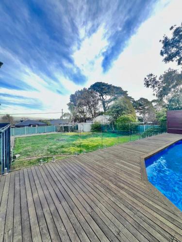 a deck with a swimming pool and a fence at 'Wallan luxury house in Wallan
