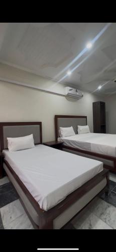 two beds in a room with at Hyatt Hotel & Aparments in Abbottabad