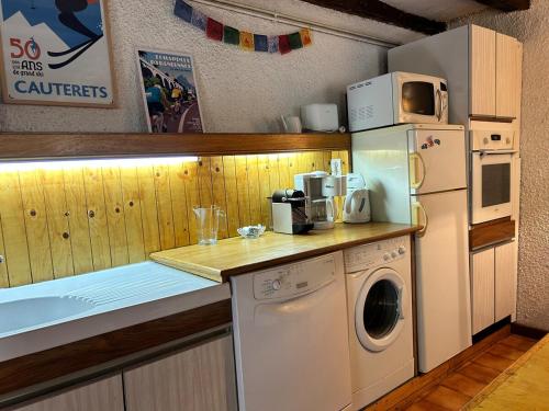 a kitchen with a washing machine and a microwave at La Petite Rocaille in Soulom