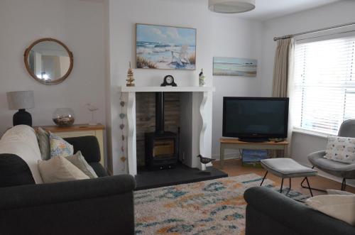 a living room with a fireplace and a television at 32 Benbane Park in Portballintrae