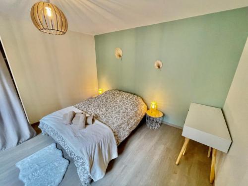 a small bedroom with a bed and two lights at Le cœur des princes in Montbéliard