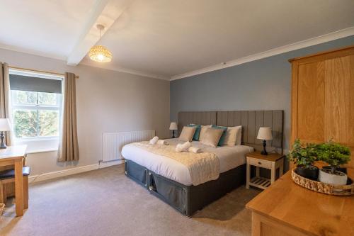 a bedroom with a bed and a desk and a window at EASTCOTE FARM - Spacious 5-Bed Home with Views, Garden & Playroom in Silloth