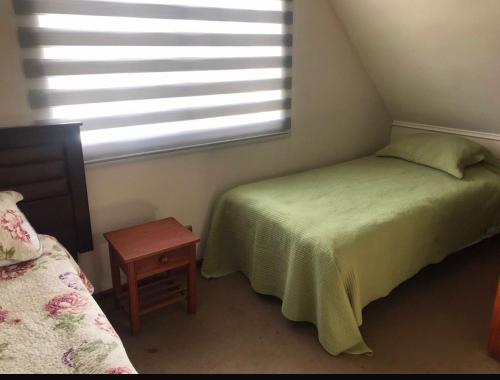 a bedroom with two twin beds and a window at Casa Parque Krahmer in Valdivia