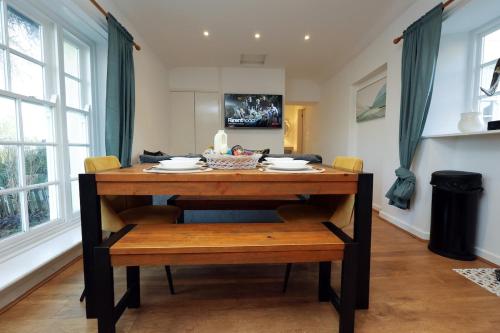 a dining room table with chairs and a wooden table at Little Gem in the Forest of Dean! Hot tub, Private garden, Dog Friendly, Smart TVs and Beautiful Historic Village Location! in Saint Briavels