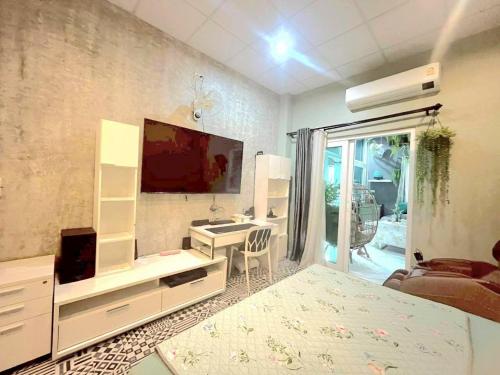 a living room with a large tv and a bedroom at Merit Courtyard Suvarnabhumi House in Lat Krabang