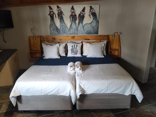 a bedroom with a bed with shoes on it at Leopard Tree Guesthouse in Springbok