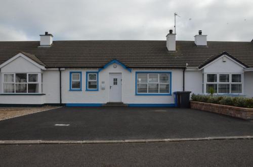 a blue and white house with a parking lot at 32 Benbane Park in Portballintrae