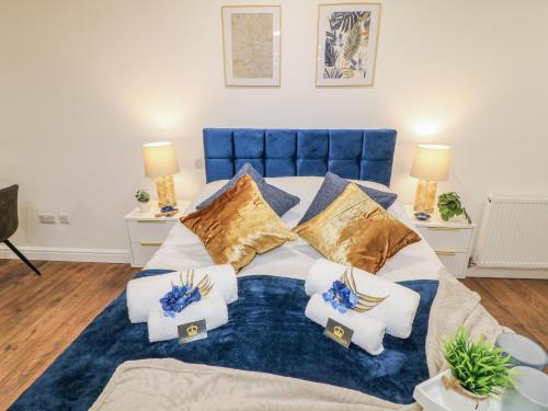 a bedroom with a bed with blue and gold pillows at Two in Peterborough
