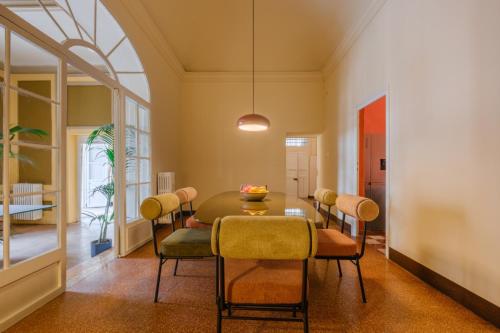 una sala da pranzo con tavolo e sedie di Unique Bologna Penthouse with Frescoes and Charm a Bologna