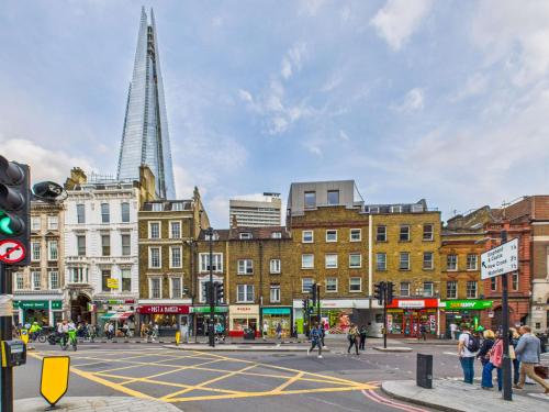 a busy city street with buildings and a tall tower at Be London - Borough Market Residences in London