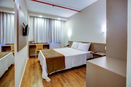 a hotel room with a large bed and a desk at Blue Tree Towers Sorriso in Sorriso