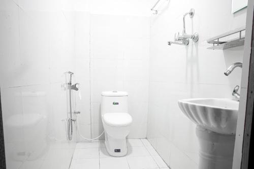 a white bathroom with a toilet and a sink at Manthali Park Inn in Rāmechhāp