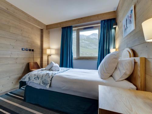 a bedroom with a bed with blue curtains and a window at Appartement spacieux avec balcon - Tignes le Lac - FR-1-641-83 in Tignes
