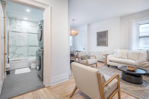 a living room with a couch and a table at 4BR Penthouse - Parking - 2 King & 2 Queen in Montréal