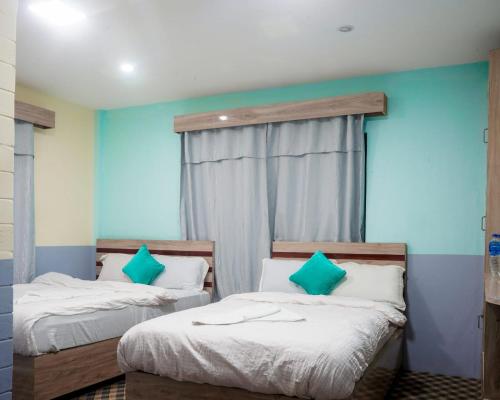 two beds in a room with blue walls at Manthali Park Inn in Rāmechhāp
