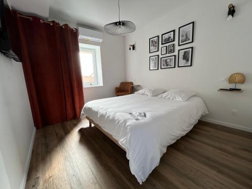 a bedroom with a large white bed and a window at L Escapade Saint Laurent - Chalon sur Saône in Chalon-sur-Saône