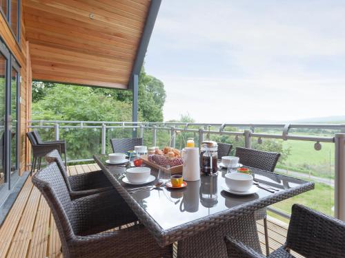 a table and chairs on a balcony with a meal on it at Strathspey Lodge in Duthil