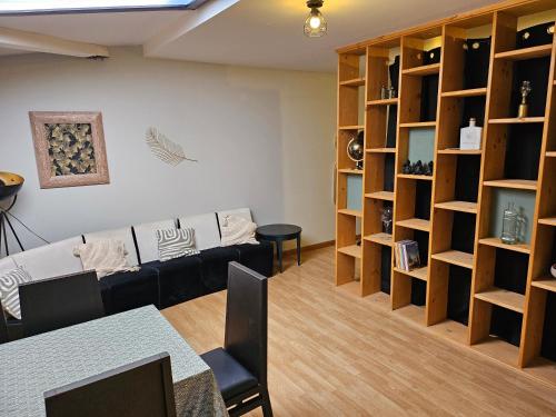 a living room with a couch and shelves at appartement Plume de repos in Marboué