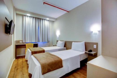 Una cama o camas en una habitación de Blue Tree Towers Sorriso
