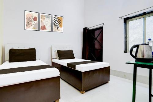 two beds sitting in a room with a window at Indian Hotel in Bareilly