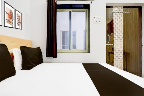 a bedroom with a white bed with a window at Indian Hotel in Bareilly