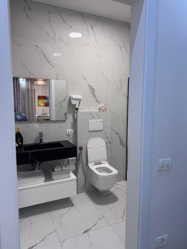a bathroom with a toilet and a sink and a mirror at Star Vollga Luxe Apartment in Durrës