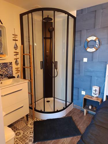 a shower in a room with a blue wall at Bienvenue chez Marceau in Le Crotoy