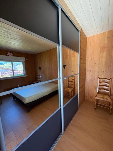 クソンリュプト・ロンジュメールにあるchalet pour amoureux à Gérardmerのベッドルーム1室(ベッド1台、窓、椅子付)